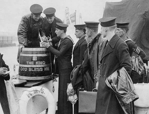 Crew of Danae class cruiser HMS Delhi mustering for the daily Grog ration